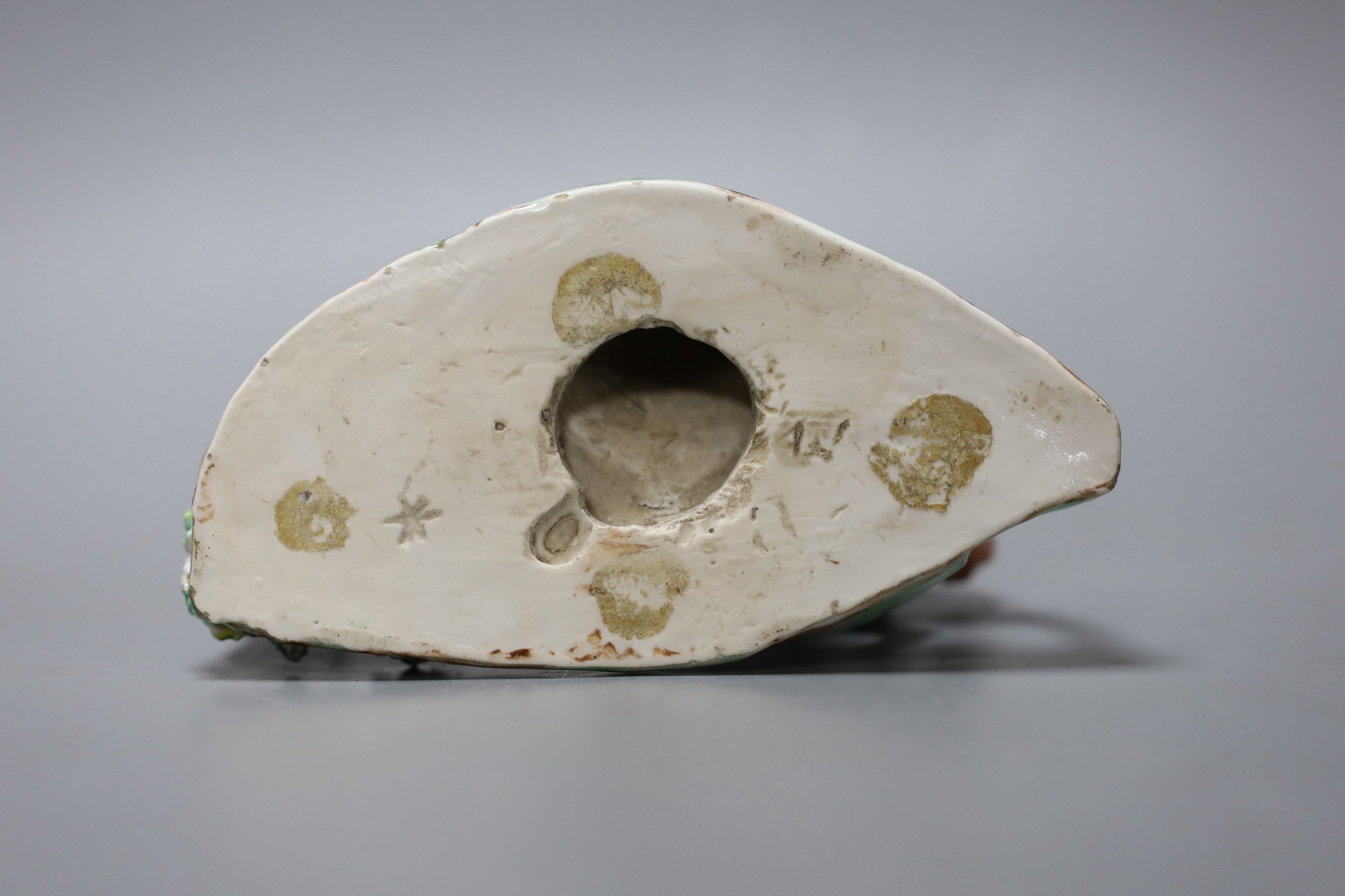 A rare Derby model of a sheep eating grass, c.1760-65, patch mark and incised mark for Isaac Farnsworth, 9cm tall